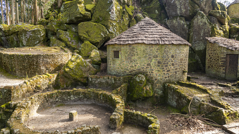A rustic stone house surrounded by rugged rocks and lush moss near Esposende