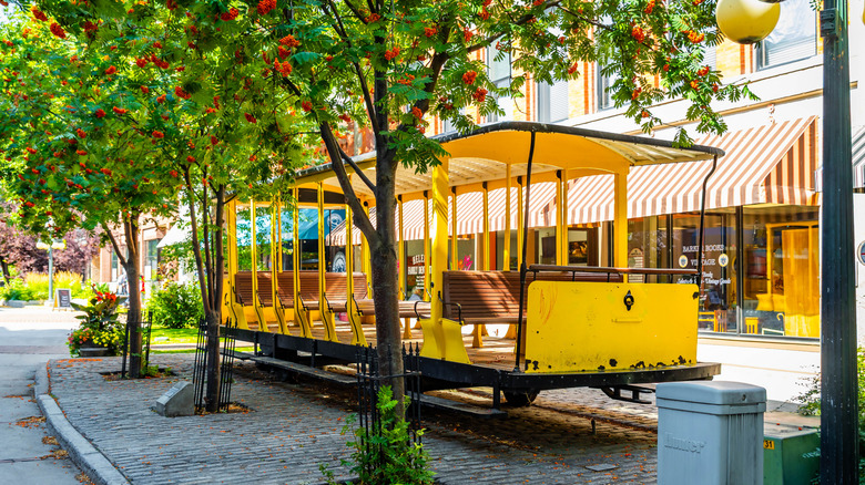A yellow streetcar on a tree-lined street in Helena, Montana