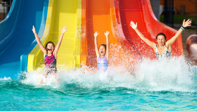 A family coming down from a water slide