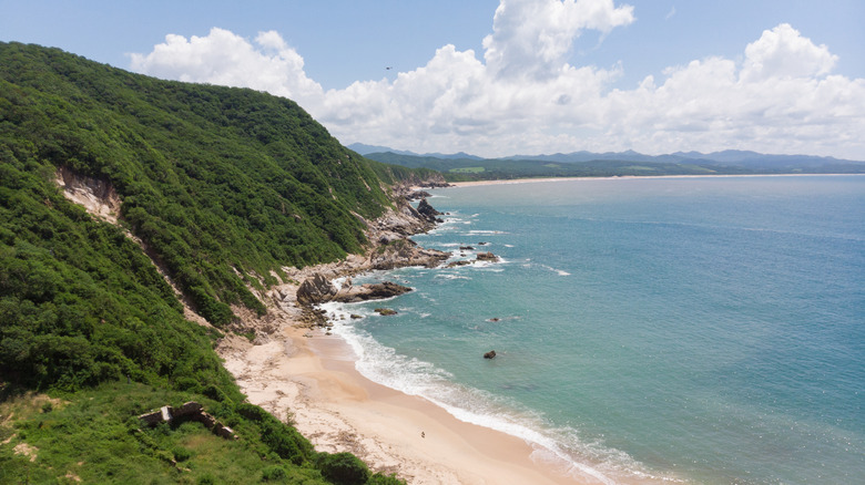 Green, jungle-covered hills at the end of Mayto Beach