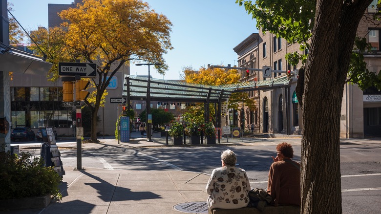 Women sitting at bus stop at Ithaca Commons