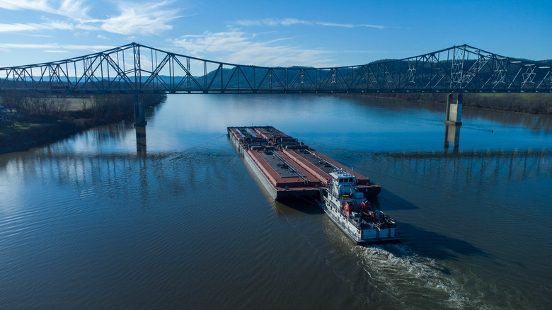 Boat on a river going underneath a bridge