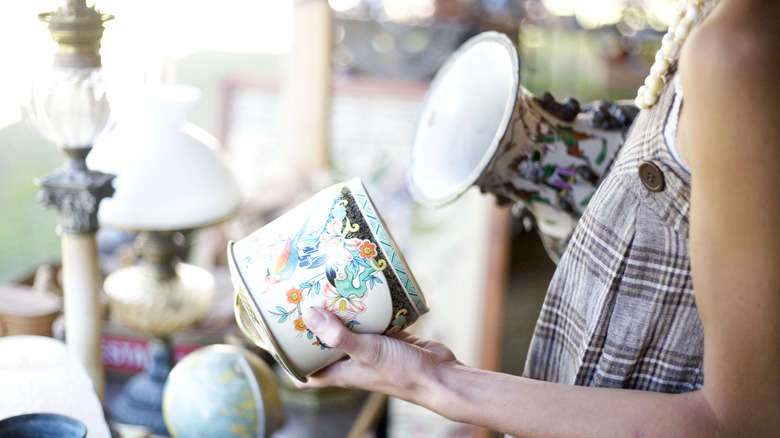 Person examining vases in an antique shop