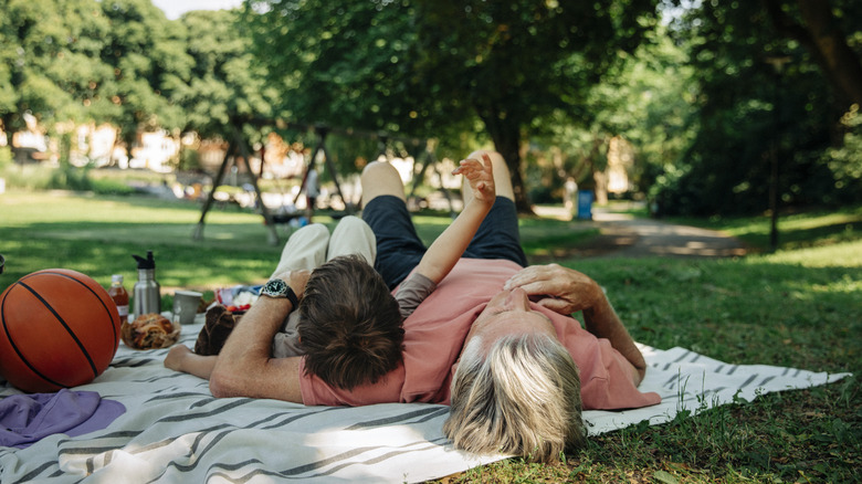 Adult and child enjoy a park picnic
