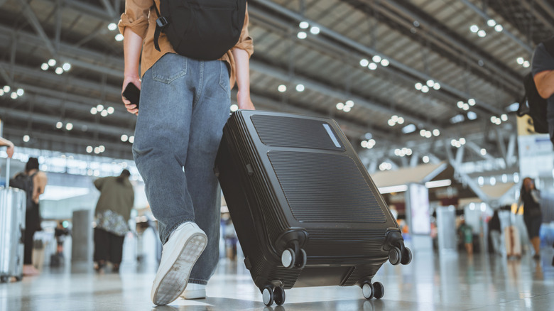 Someone rolling luggage through an airport