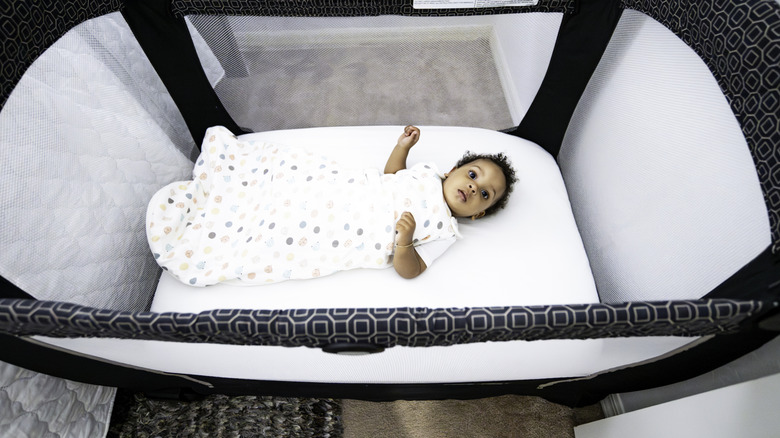 Baby in a portable crib