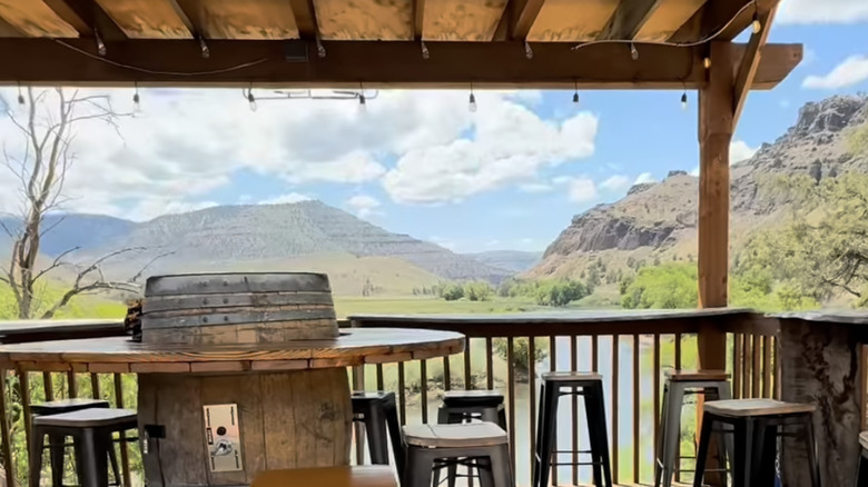 An exterior shot of patio at Ben's Place Bar overlooking a river.