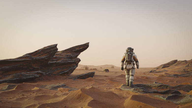 Astronaut walking through a Mars-like landscape