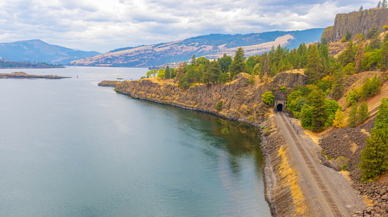 Railroad running through mountains by the sparkling Columbia river
