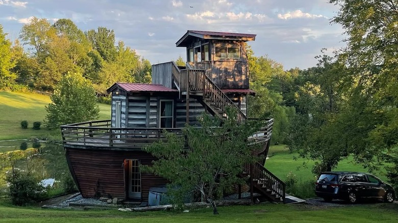 Boat-shaped cottage next to a green forest at Kelly's Jubilee