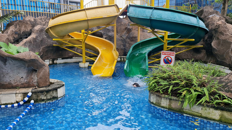 Two waterslides emptying into a pool