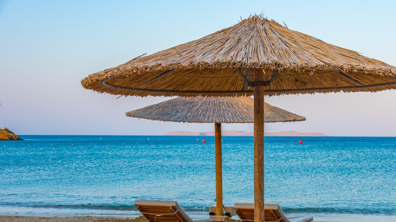 Beach chairs and umbrellas on Vai Beach, overlooking turquoise water