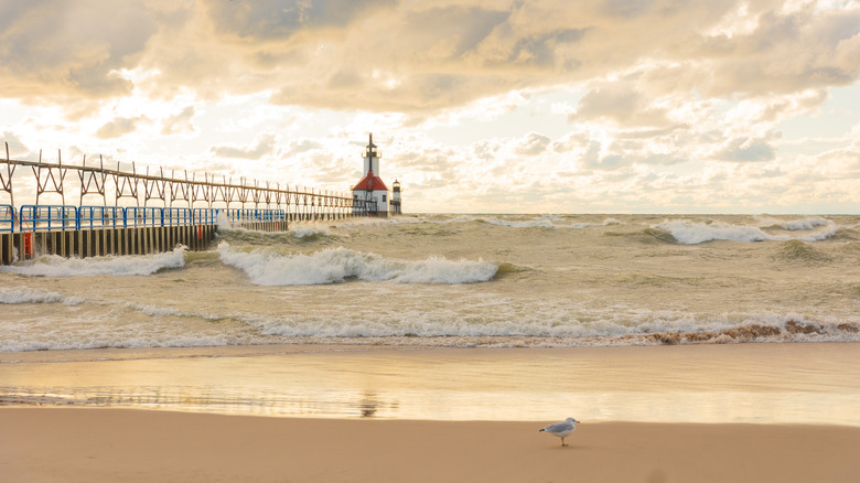 crashing waves highlight the lighthouse in the background