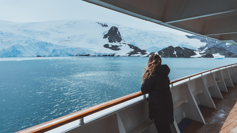 a woman on a cruise looks at a glacier