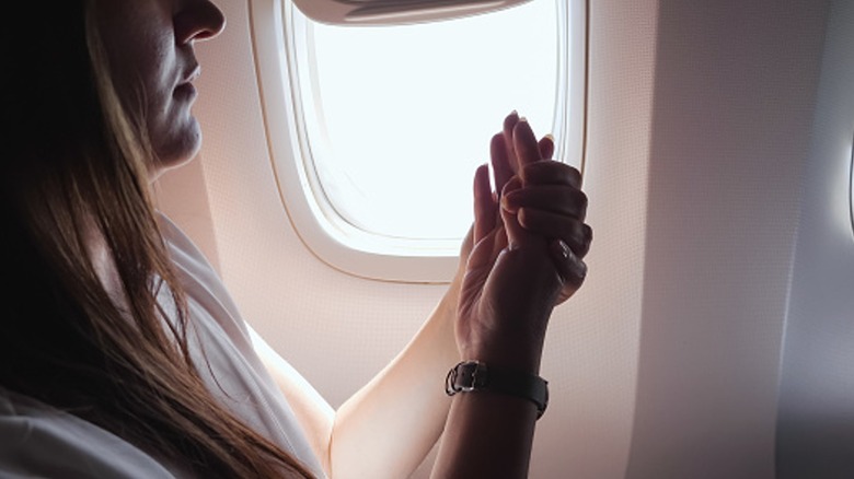 Woman applying lotion in flight