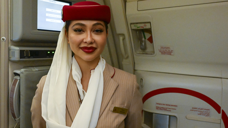 A flight attendant by the plane door