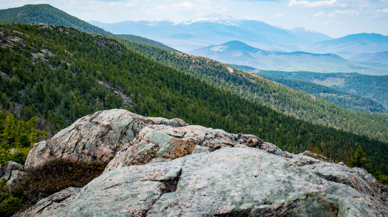 Rocks on Moat Mountain overlooking forested mountains in New Hampshire