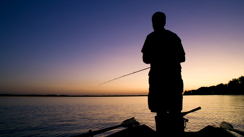 Silhouette of a person fishing off a boat in Wisconsin