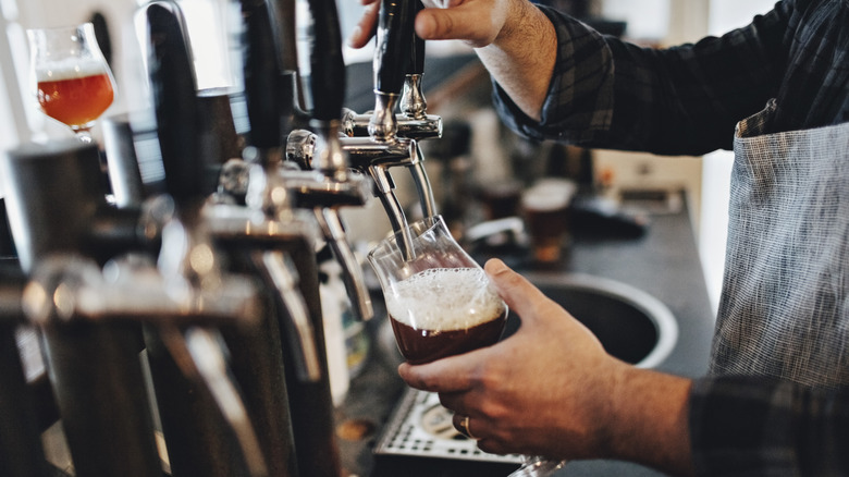 A bartender pours a beer from the tap