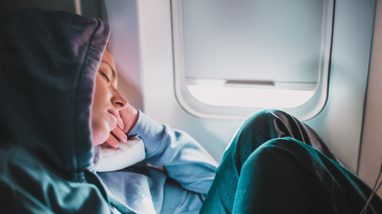 Someone sleeping comfortably on a plane