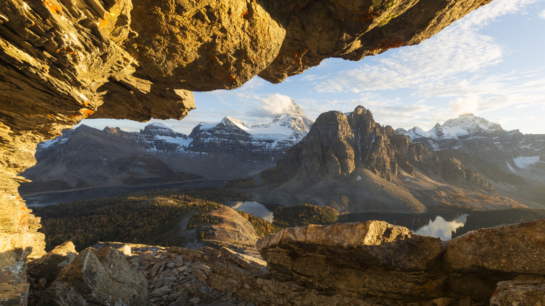 Looking out at the Mt. Assiniboine park vista under a low hanging rock ceiling