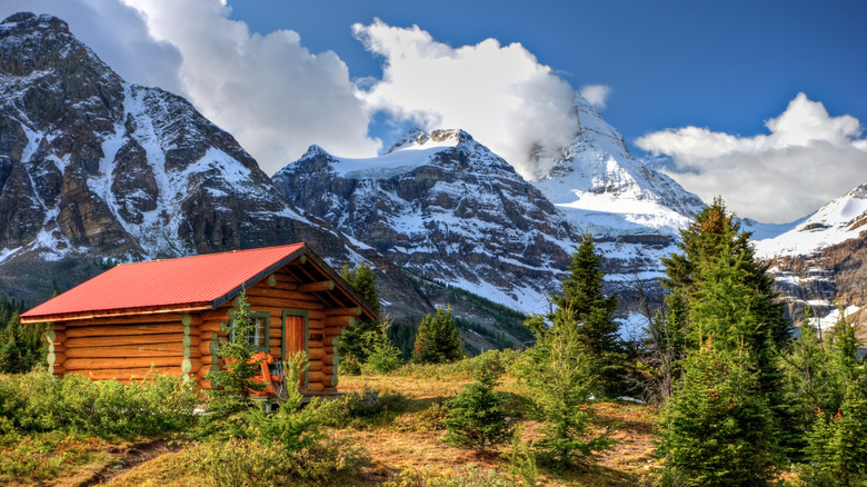 A log cabin with a red roof in the natural scenery of Mt. Assiniboine Provincial Park