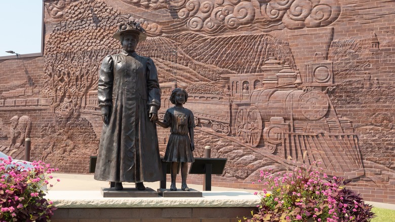 A statue of a woman in child representing the history of orphan trains in Concorida