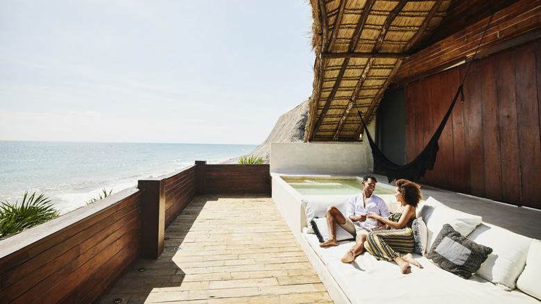 Couple sitting on a resort balcony overlooking water