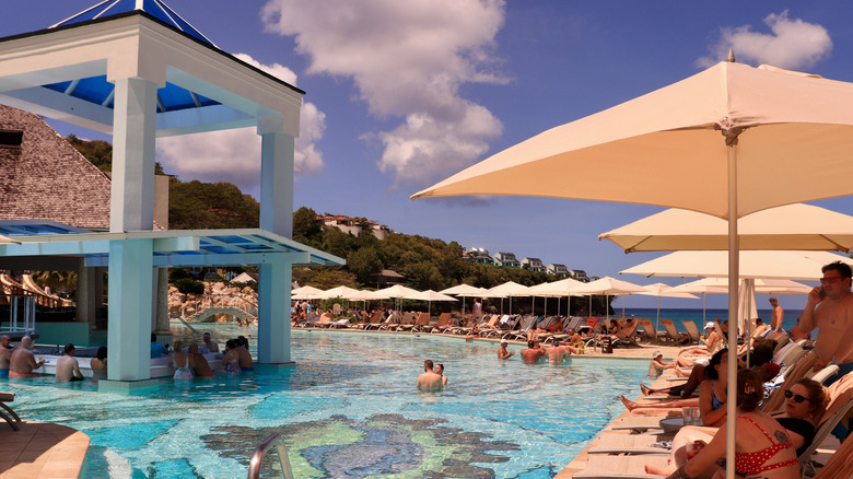 People in the water and at a swim-up bar in a resort pool
