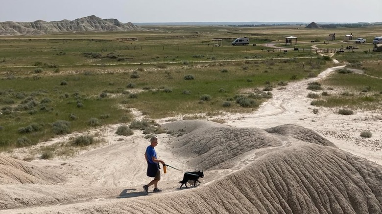 A man walks a dog at Toadstool Geologic Park.
