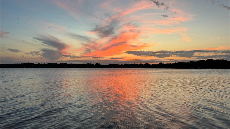 A fiery sunset reflected on water at Lake Minnewashta Regional Park, Minnesota