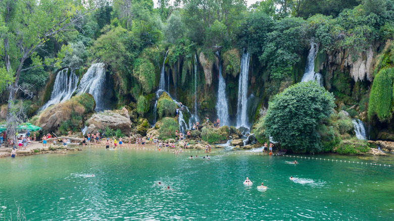 People swimming in Kravica Waterfall in summer