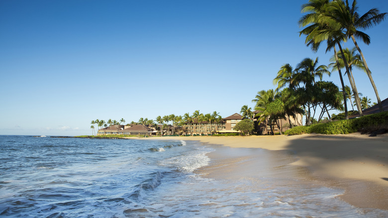 Poipu Beach in Kauai, Hawai'i, with a resort off in the distance