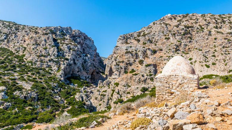 Stone hut with a domed roof surrounded by rugged cliffs, Saria Island