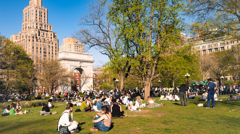 People sitting on the lawn in Washington Square Park on a clear spring day