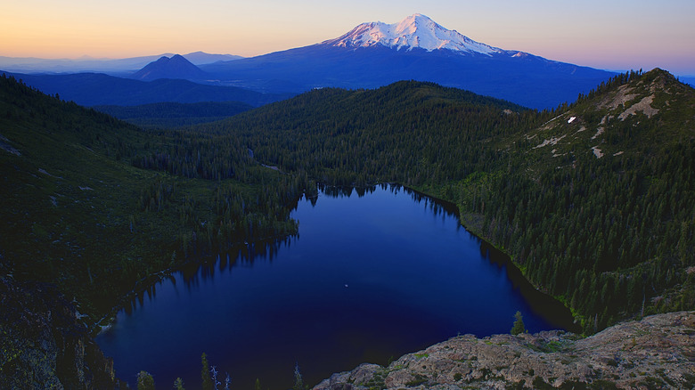 Heart-shaped Heart Lake, seen from above, surrounded by evergreen forest and mountains