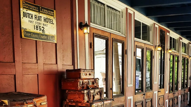 Vintage suitcases stacked in front of a Victorian-era hotel in Dutch Flat, California.
