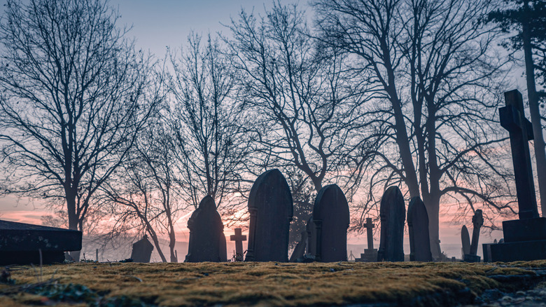 Gravestones silhouetted against sunset