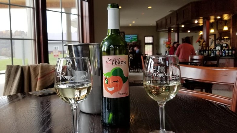 Two filled wine glasses sit on a table in PromiseLand Winery's indoor seating area