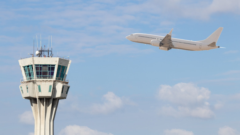 Airplane flying over air traffic control tower