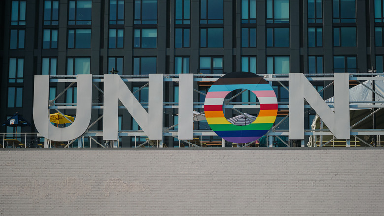 Union Station exterior signage with one letter in rainbow coloring.