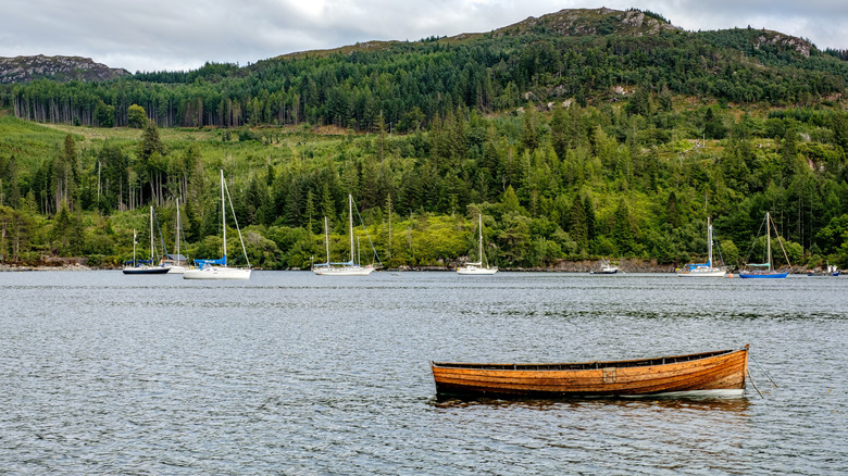 A canoe and sailboats tied onto the loch