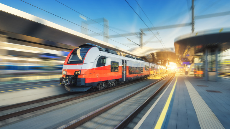 A high-speed train on the tracks at sunset