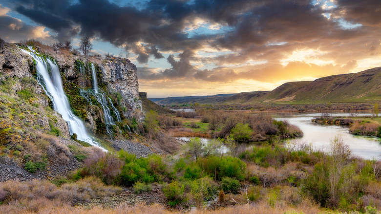 Several seasonal waterfalls cascade down into the Snake River at sunset, near Jerome, Idaho