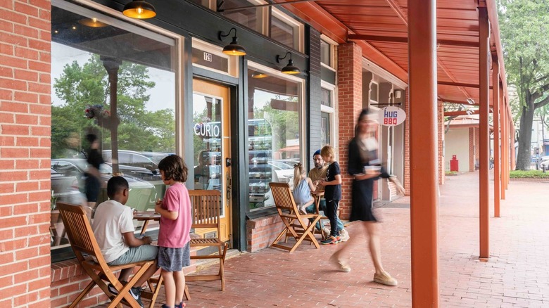 People sitting and walking in front of shops, Lancaster Texas