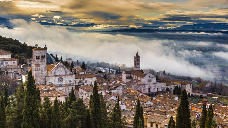 ancient buildings on hillside with clouds