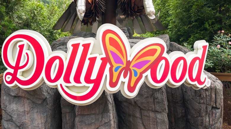 The entrance sign for Dollywood, Tennessee featuring pink lettering and a butterfly
