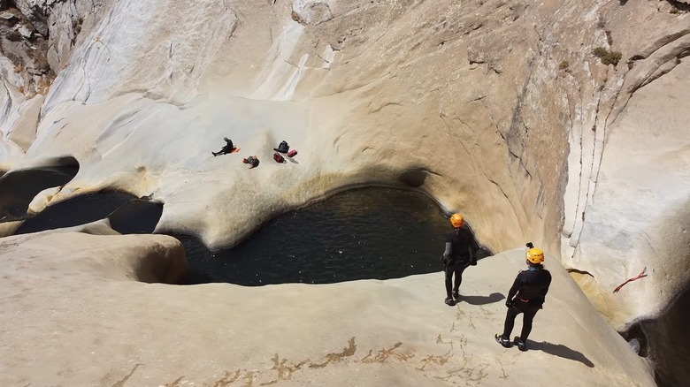 Two hikers in safety gear overlooking Seven Teacups water basins