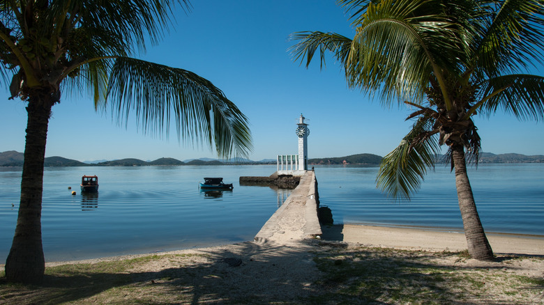 A view of the beach and a modernist lighthouse on Ilha de Paqueta, Brazil