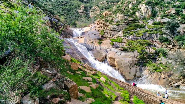 People sitting on rocks overlooking Three Sisters Falls